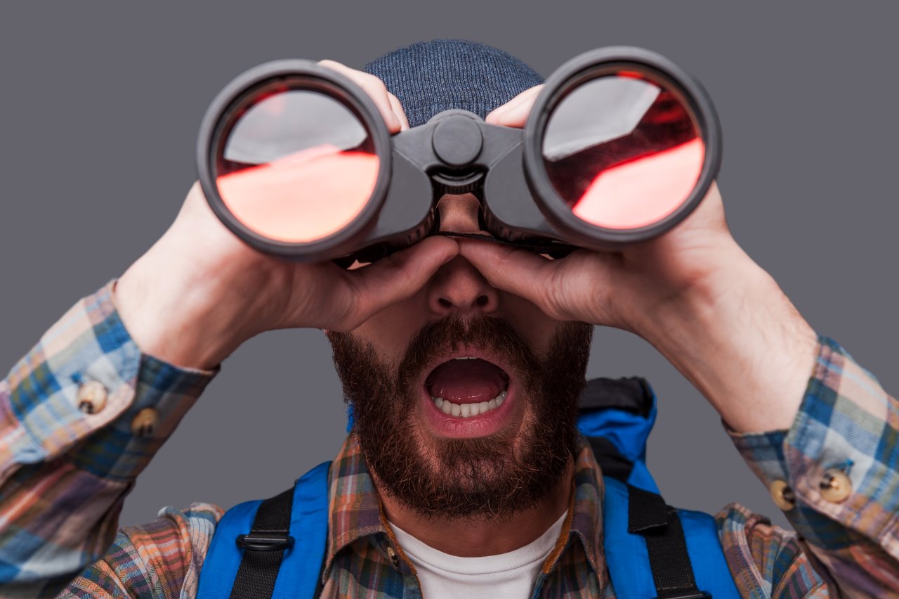 man shocked while using a full-sized binoculars
