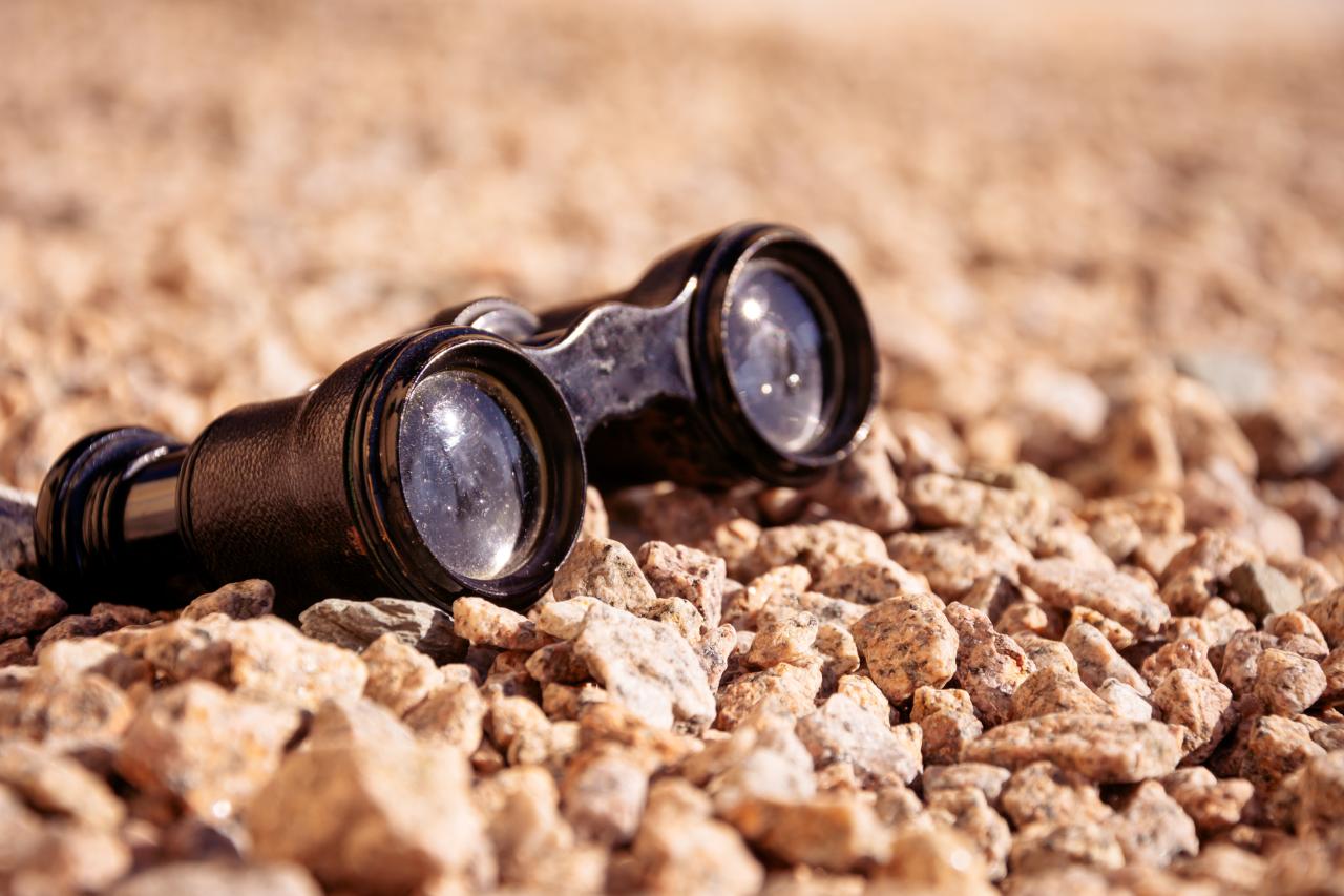 old binoculars on pebbles