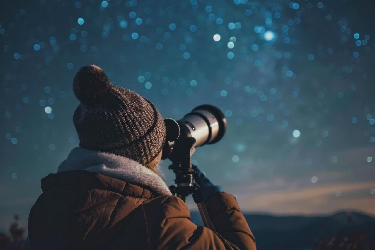 a person looking at the stars through a telescope